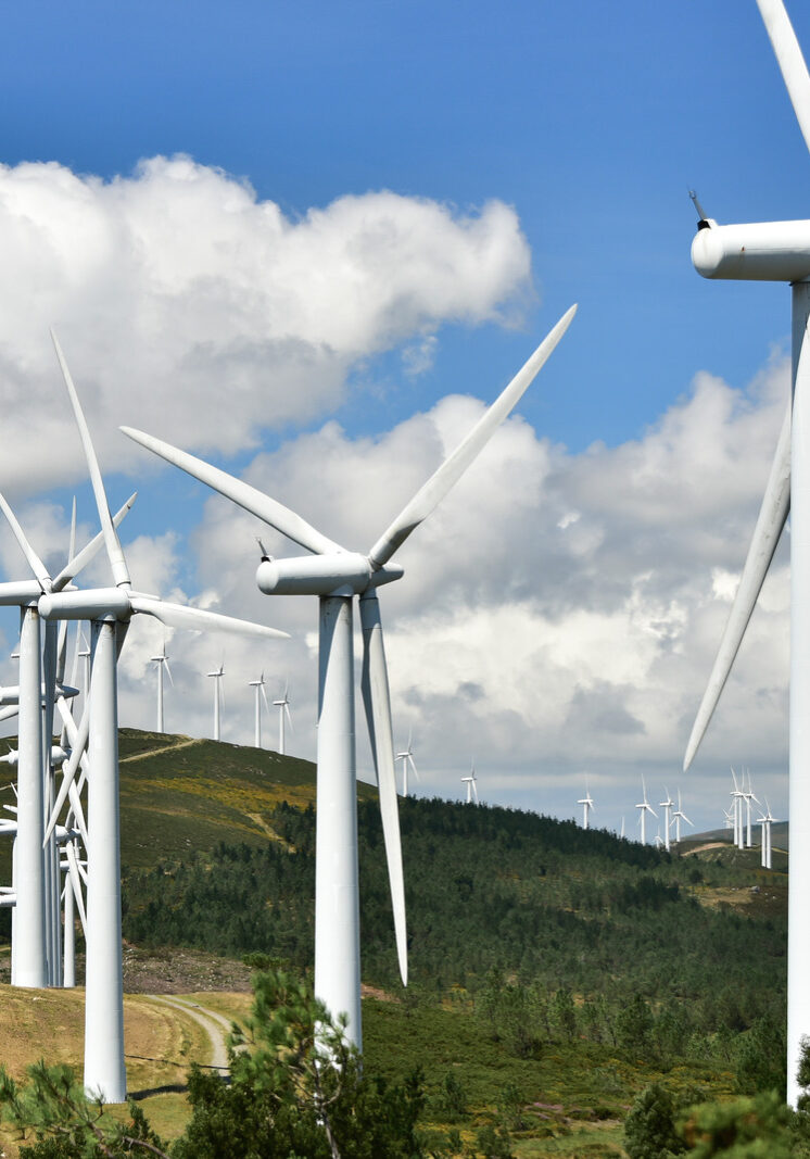 Wind power plant under blue sky with clouds